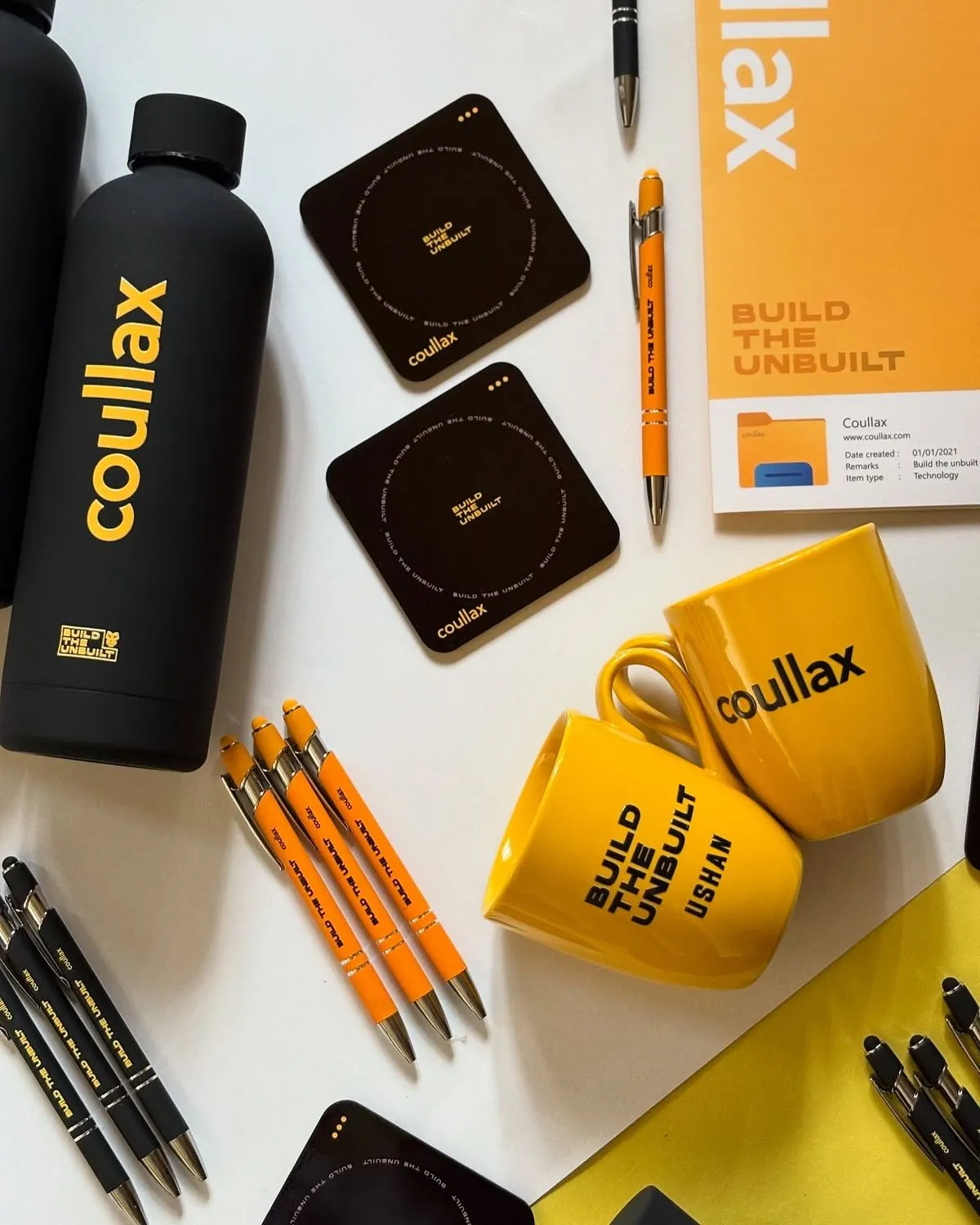 Personalised corporate gift set with branded water bottle, coasters, pens, mugs, and notebook